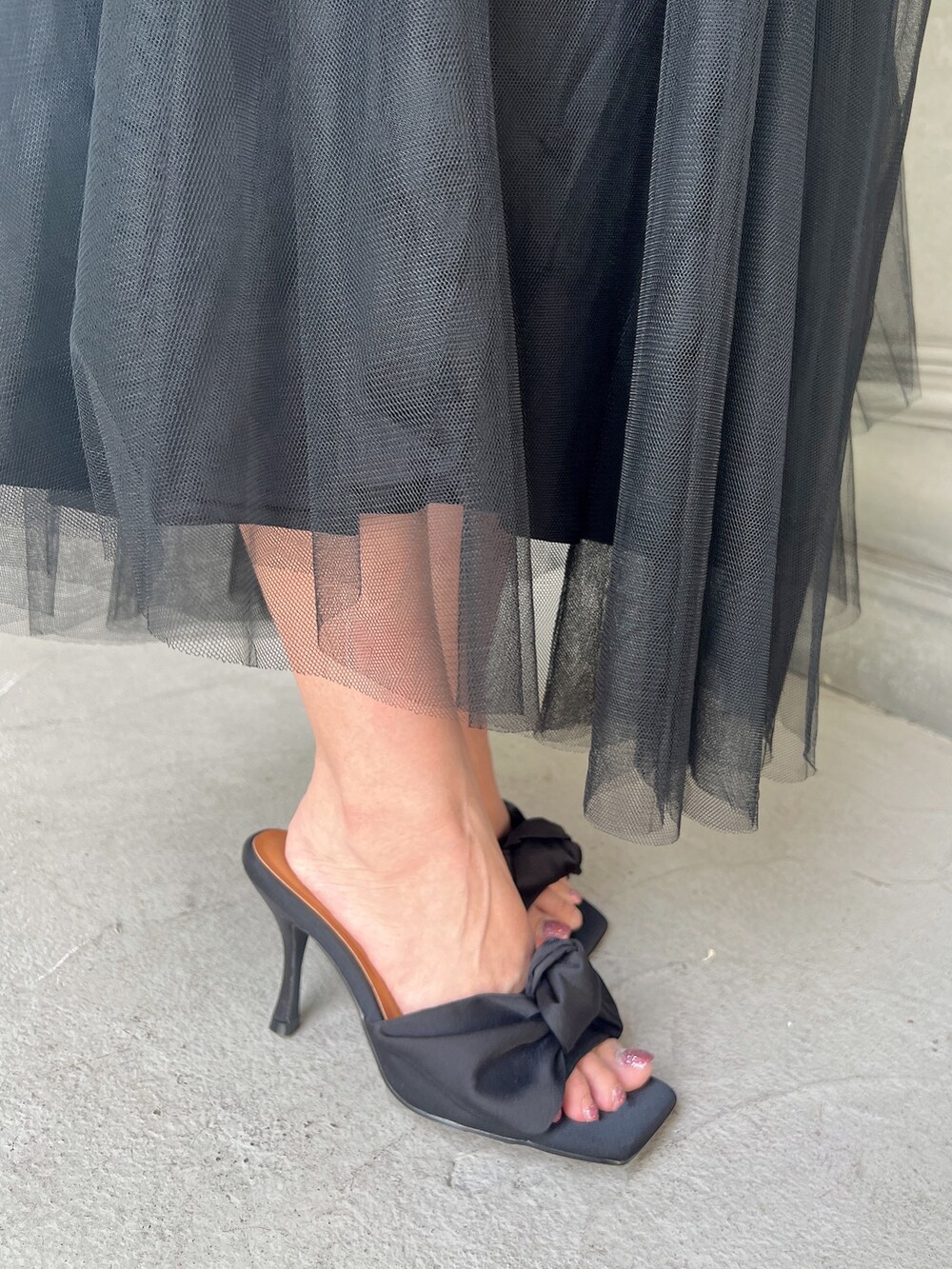 ホワイト系のTシャツ/カットソー、ブラック系のスカート、レッド系のショルダーバッグを着用したレディースの夏コーディネートの7枚目の写真