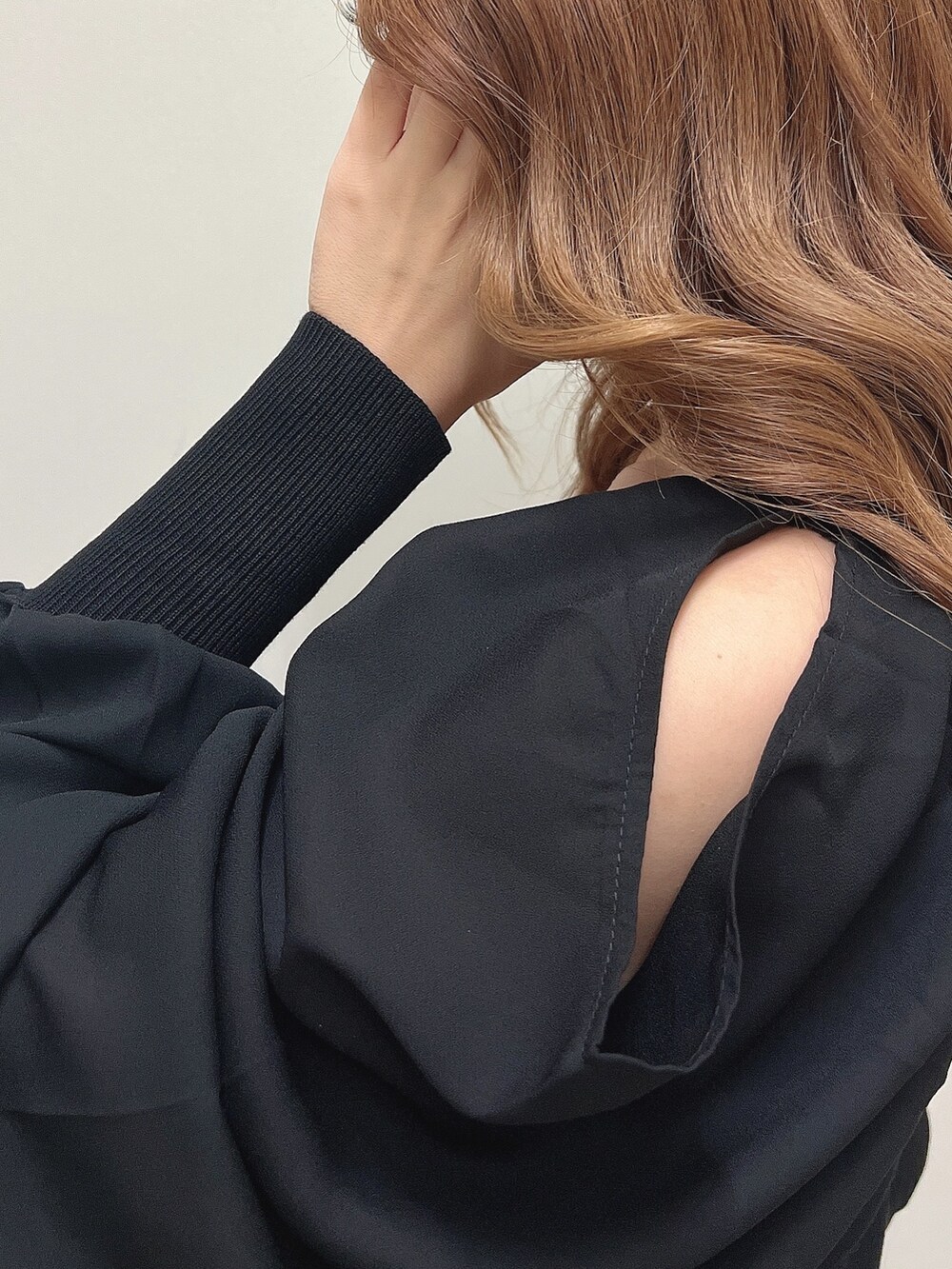 ベージュ系のライダースジャケット、ブラック系のワンピース、ベージュ系のサンダルを着用したレディースの秋コーディネートの3枚目の写真