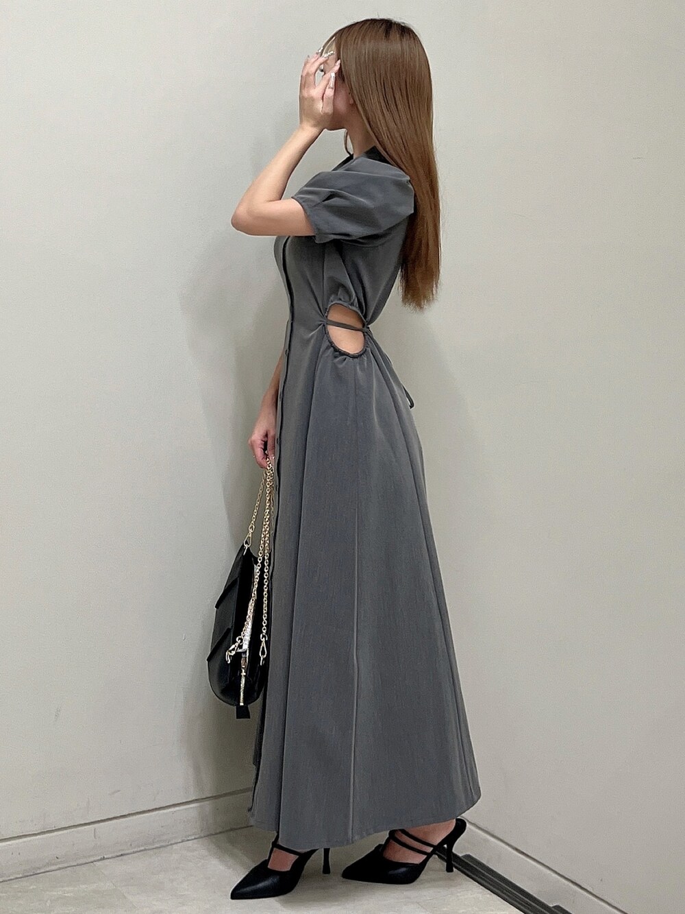 グレー系のワンピース、ブラック系のパンプス、ブラック系のハンドバッグを着用したレディースの春コーディネートの4枚目の写真