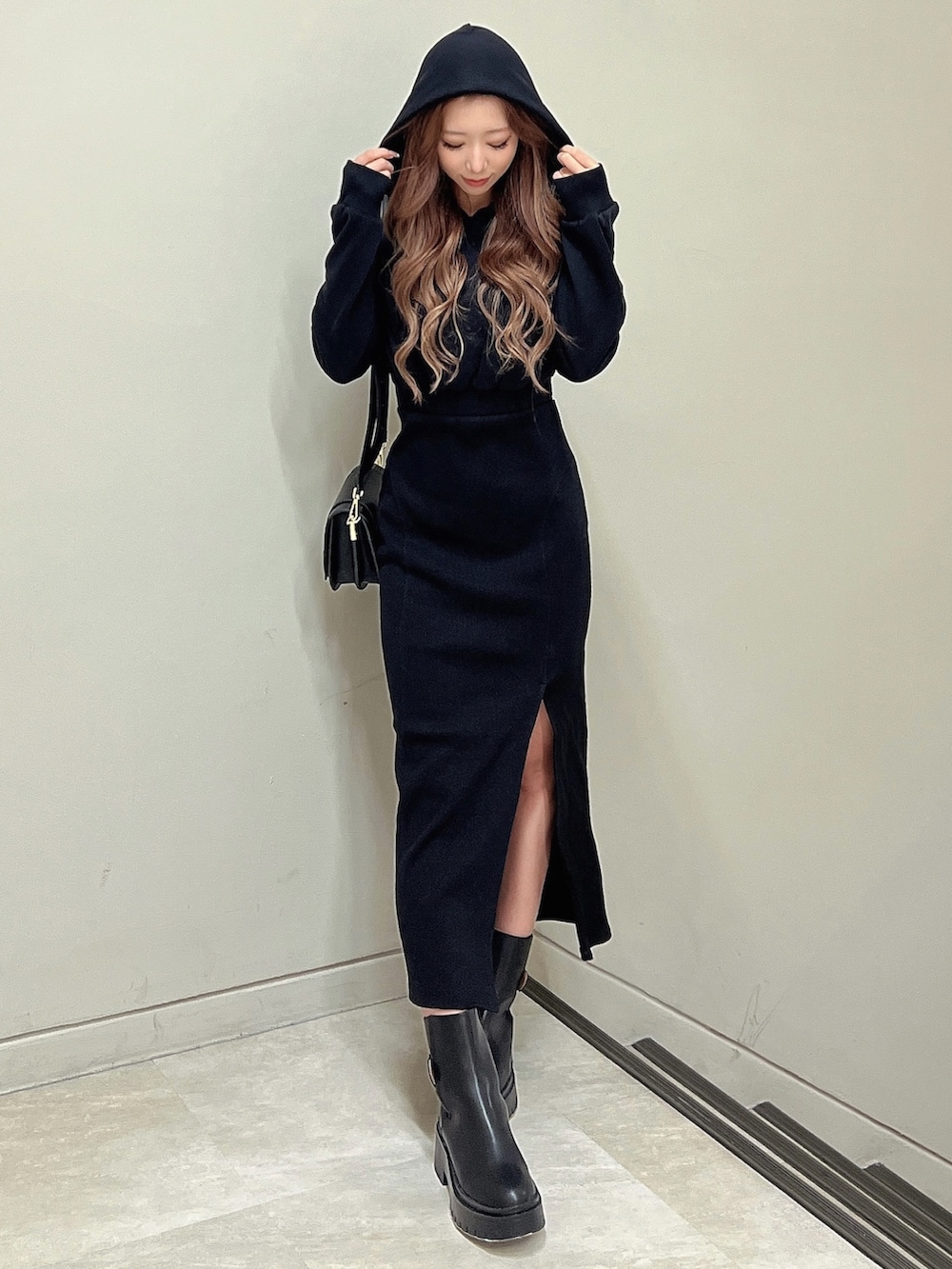 ブラック系のブーツ、ブラック系のショルダーバッグ、ブラック系のワンピースを着用したレディースの秋コーディネートの4枚目の写真