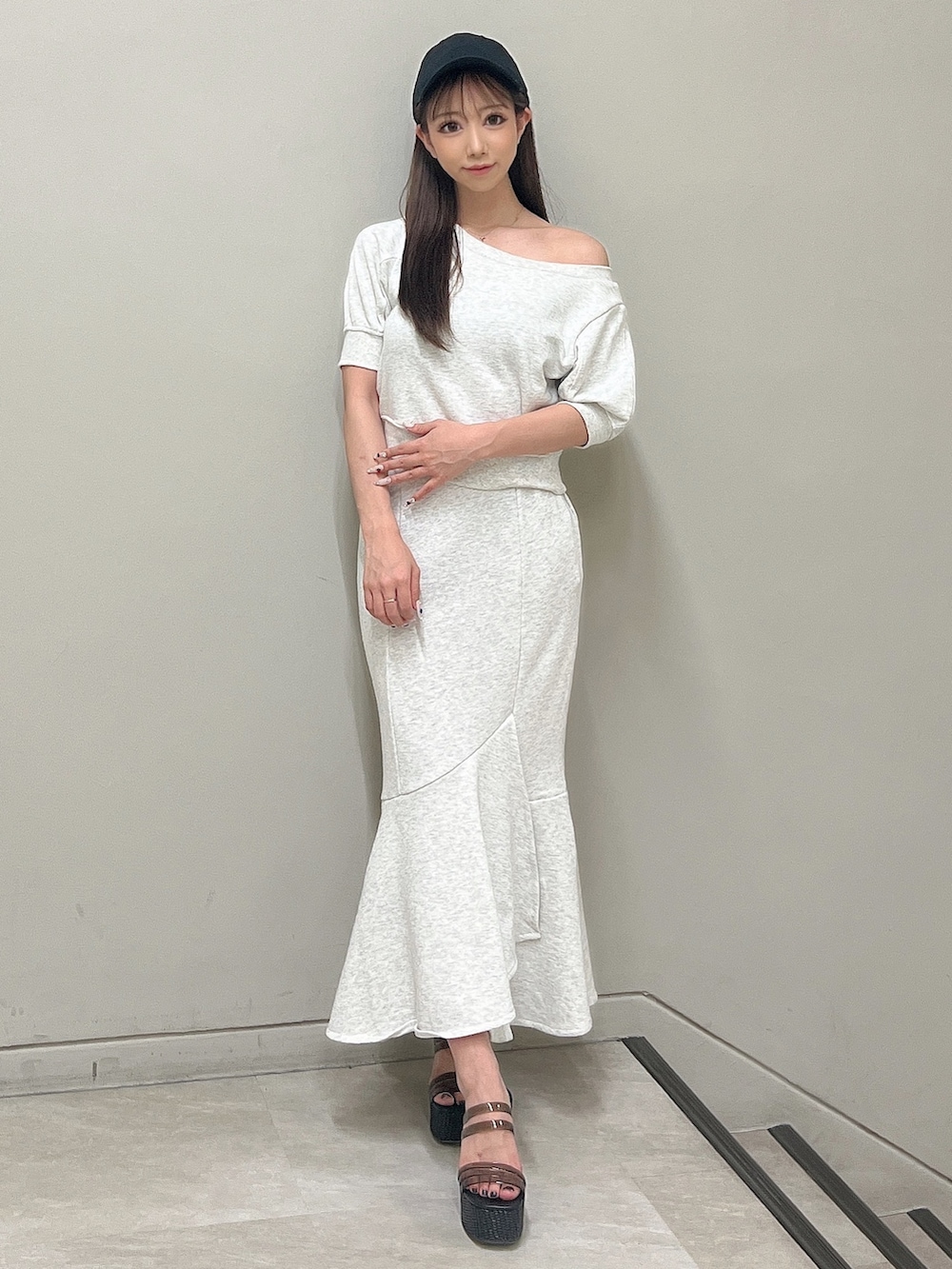 グレー系のTシャツ/カットソー、グレー系のスカート、ブラック系のサンダルを着用したレディースの春コーディネートの3枚目の写真