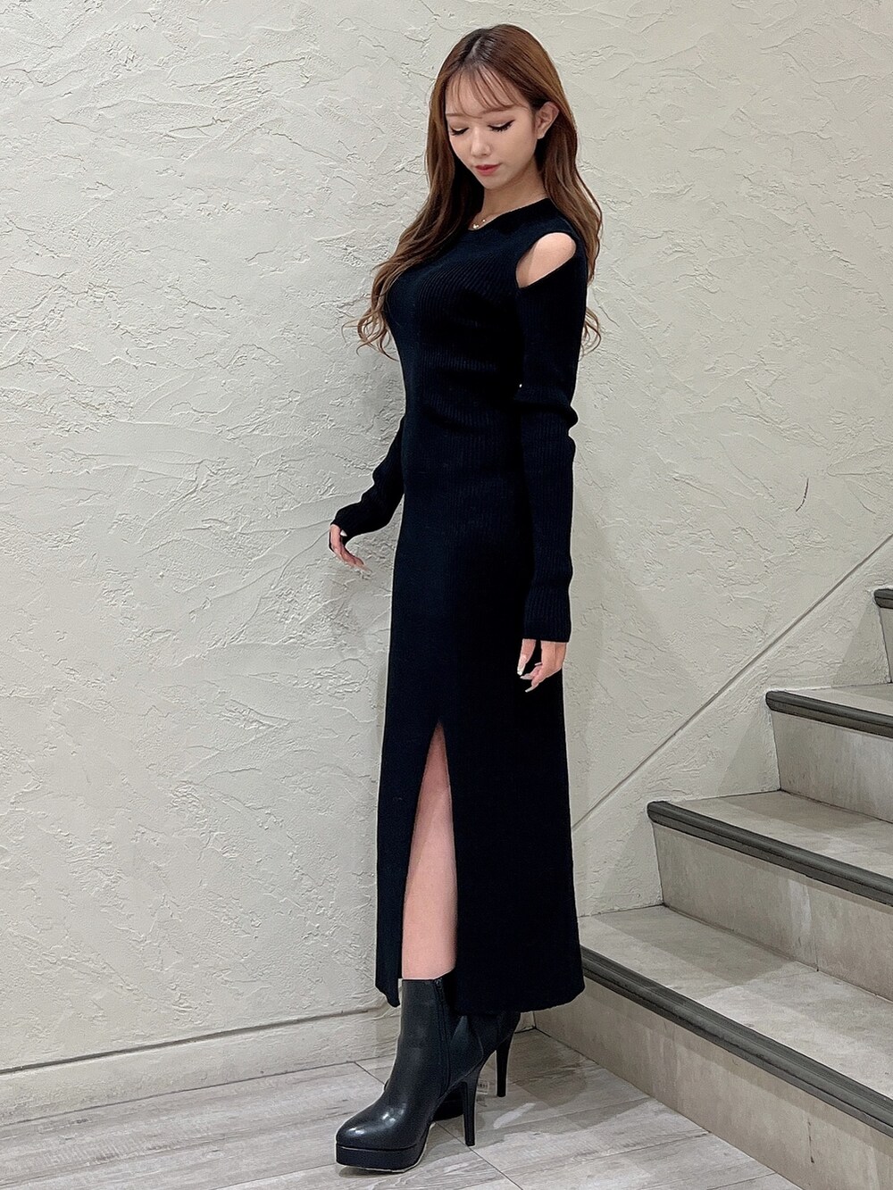 ブラック系のワンピース、ブラック系のブーツ、ホワイト系のブルゾンを着用したレディースの秋コーディネートの2枚目の写真