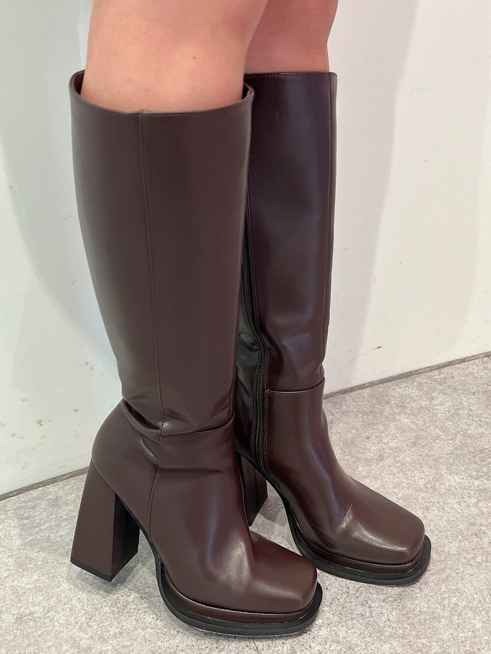 ホワイト系のワンピース、ブラウン系のブーツ、ブラウン系のショルダーバッグを着用したレディースの冬コーディネートの7枚目の写真