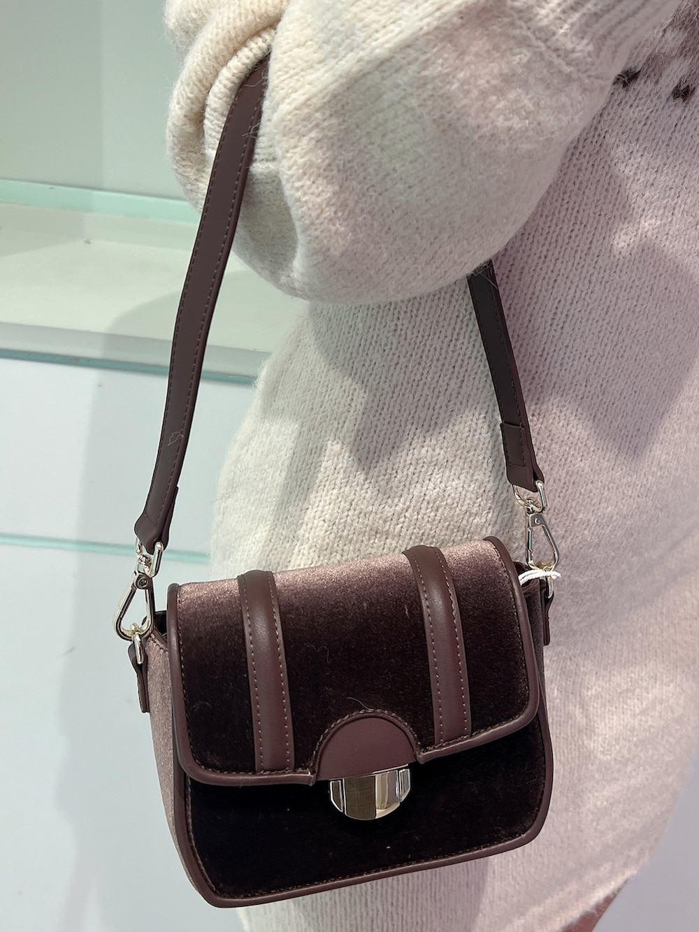 ホワイト系のワンピース、ブラウン系のブーツ、ブラウン系のショルダーバッグを着用したレディースの冬コーディネートの5枚目の写真