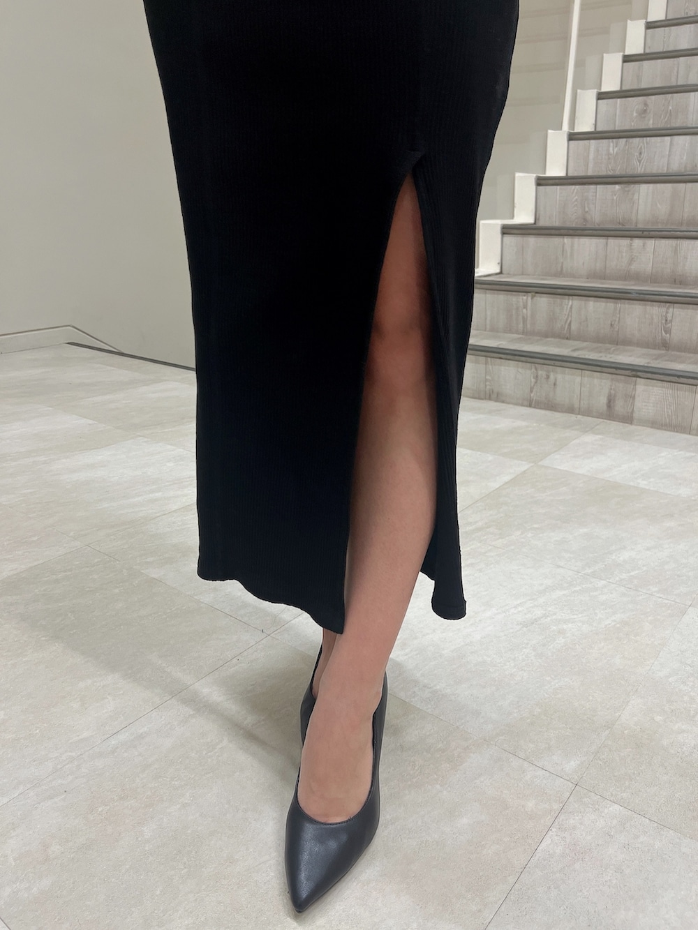 ブラック系のワンピース、ブラック系のライダースジャケット、ブラック系のパンプスを着用したレディースの冬コーディネートの7枚目の写真