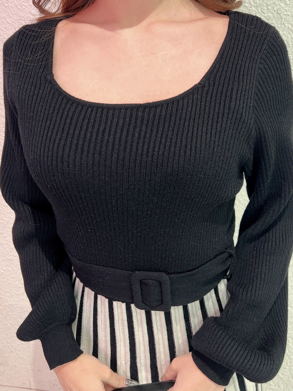 ブラック系のワンピース、ブラック系のハンドバッグ、ブラック系のブーツを着用したレディースの冬コーディネートの6枚目の写真