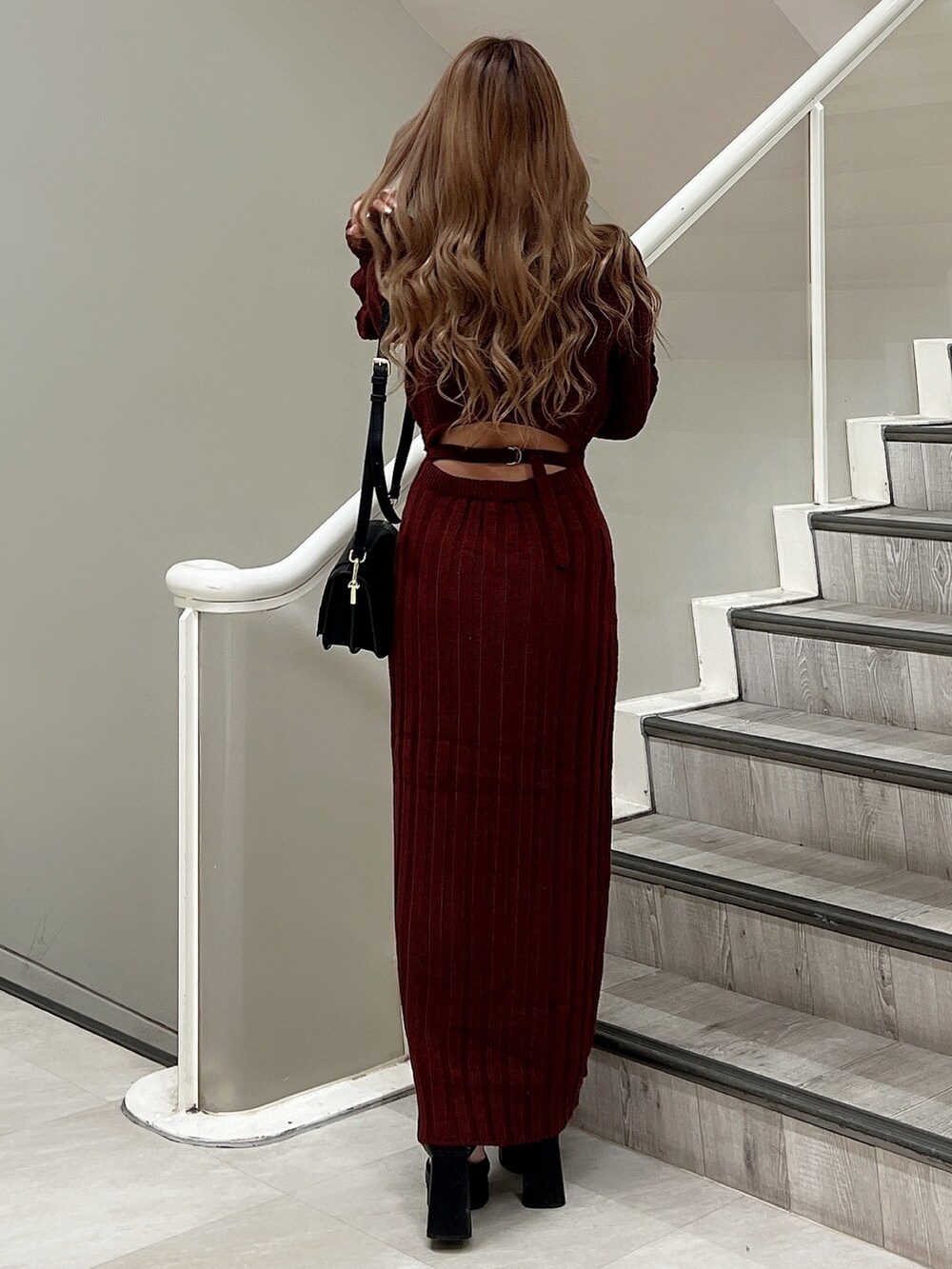 ブラック系のパンプス、ブラック系のショルダーバッグ、レッド系のワンピースを着用したレディースの秋コーディネートの4枚目の写真