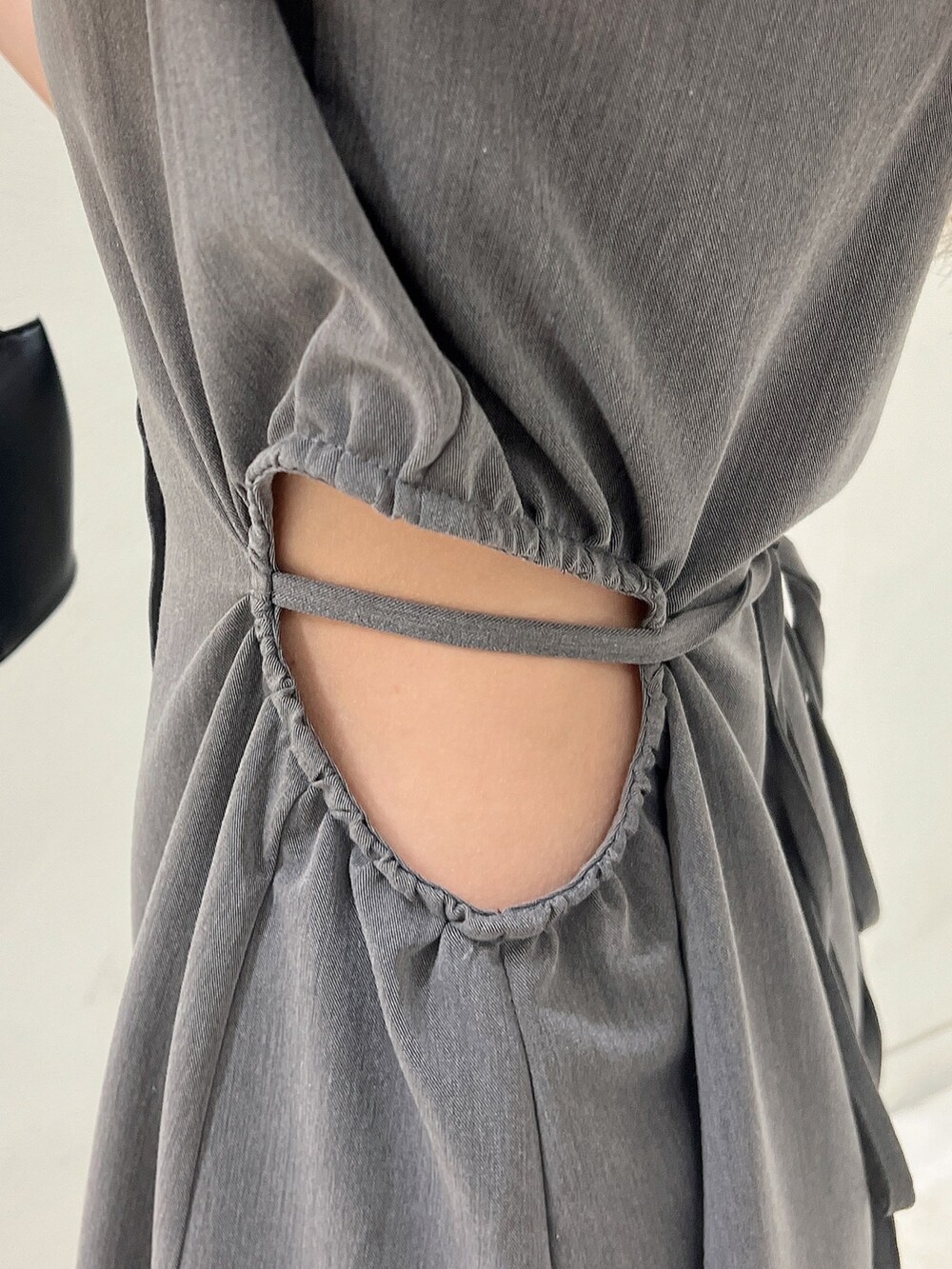 グレー系のワンピース、ブラック系のパンプス、ブラック系のハンドバッグを着用したレディースの春コーディネートの8枚目の写真