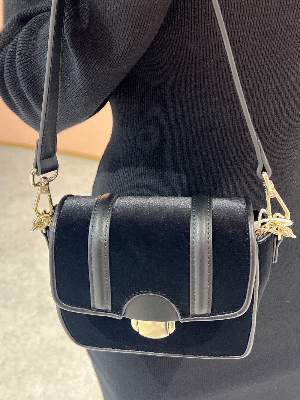 ブラック系のワンピース、ブラック系のショルダーバッグ、ブラック系のパンプスを着用したレディースの冬コーディネートの6枚目の写真