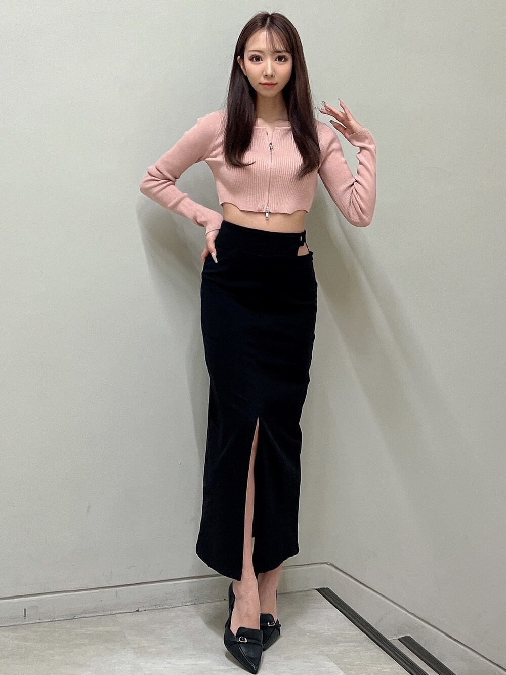 ブラック系のスカート、ピンク系のニット/セーター、ブラック系のパンプスを着用したレディースの冬コーディネートの2枚目の写真