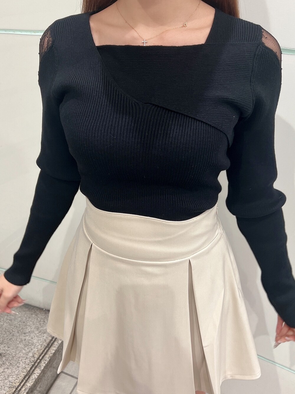 ホワイト系のライダースジャケット、ホワイト系のスカート、ブラック系のニット/セーターを着用したレディースの冬コーディネートの6枚目の写真