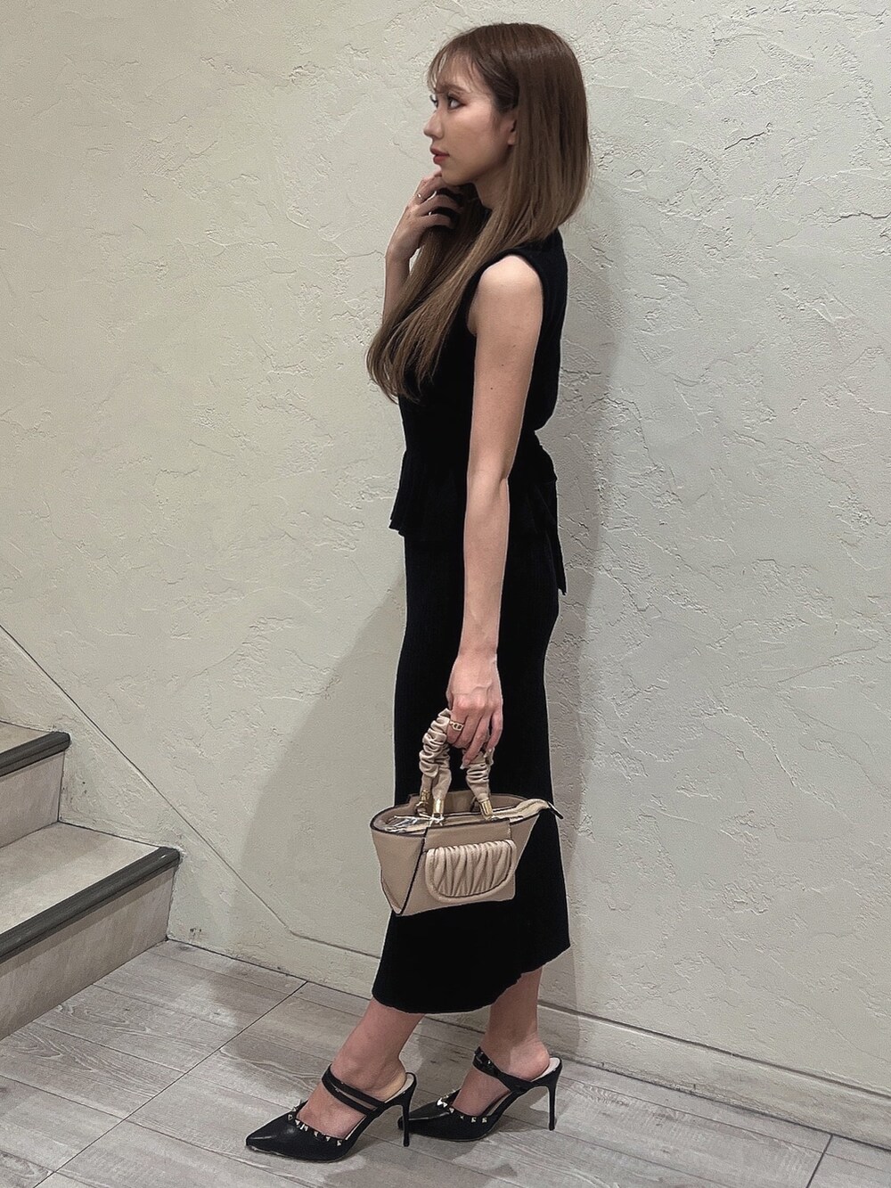 ブラック系のニット/セーター、ブラック系のパンプス、ブラック系のスカートを着用したレディースの春コーディネートの2枚目の写真