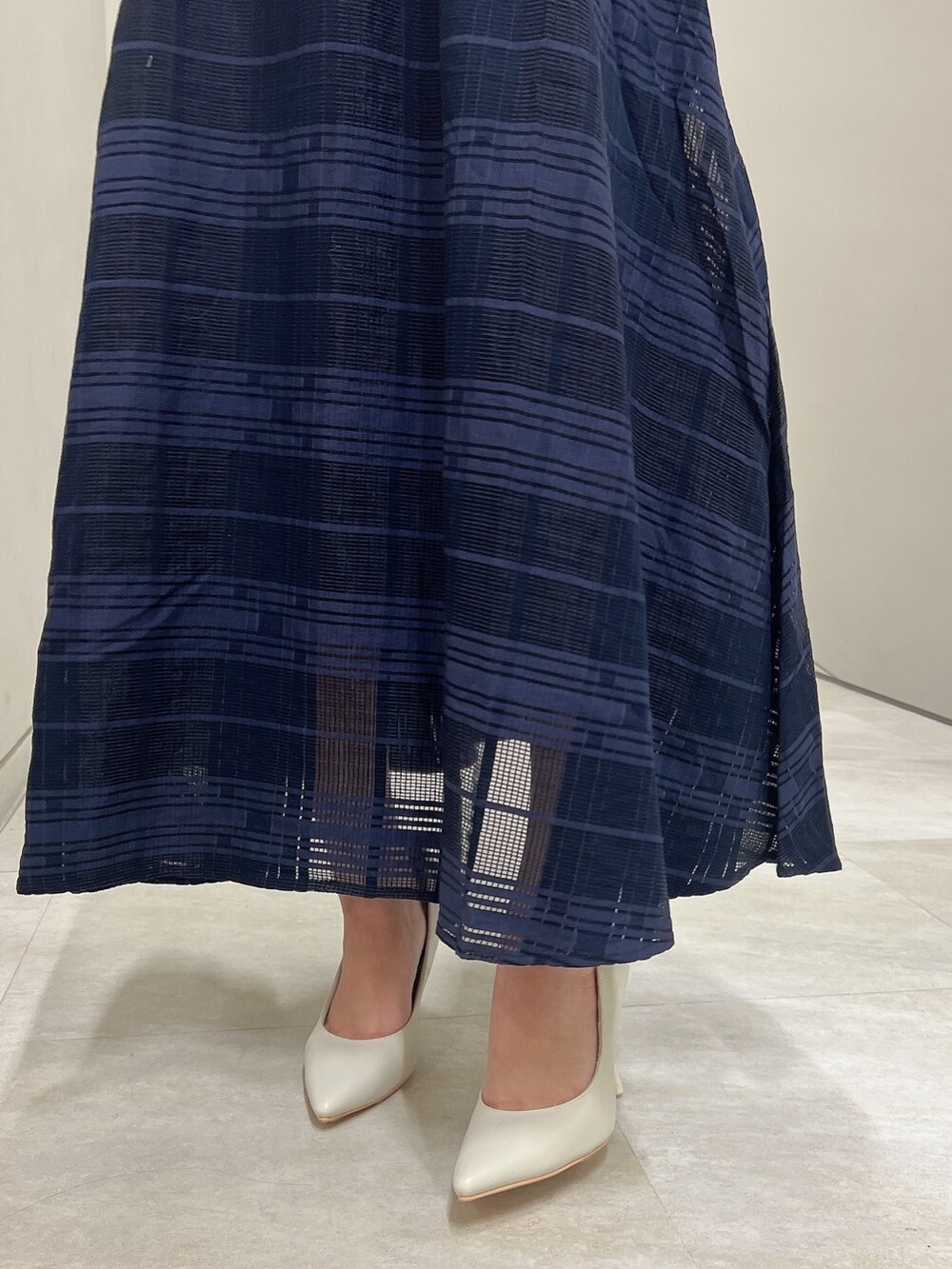 ホワイト系のパンプス、ブルー系のワンピース、ホワイト系のハンドバッグを着用したレディースの冬コーディネートの8枚目の写真