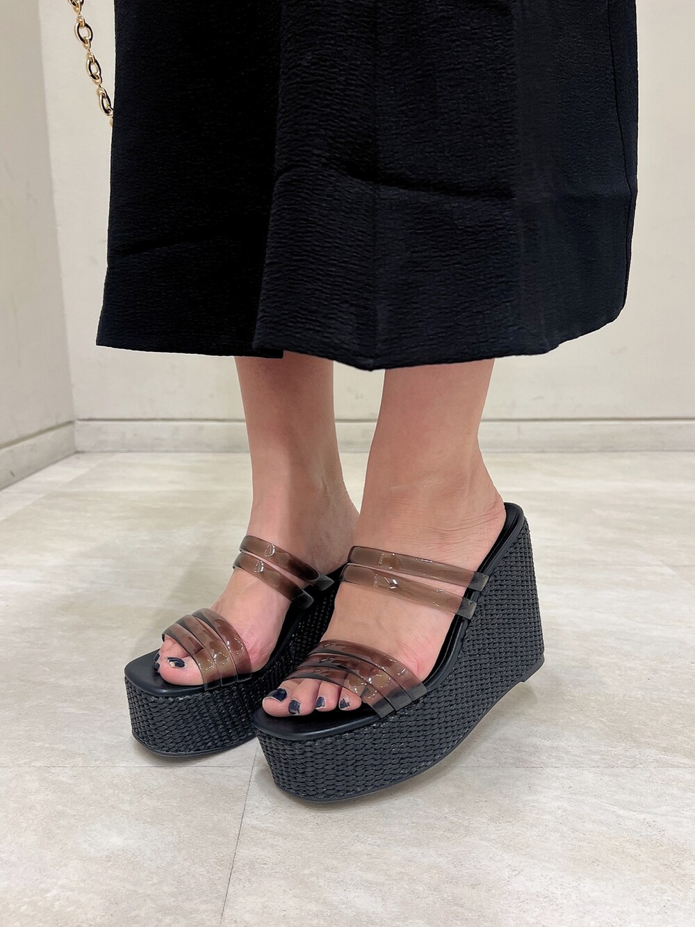 ブラック系のワンピース、ブラック系のサンダル、ブラック系のハンドバッグを着用したレディースの春コーディネートの8枚目の写真