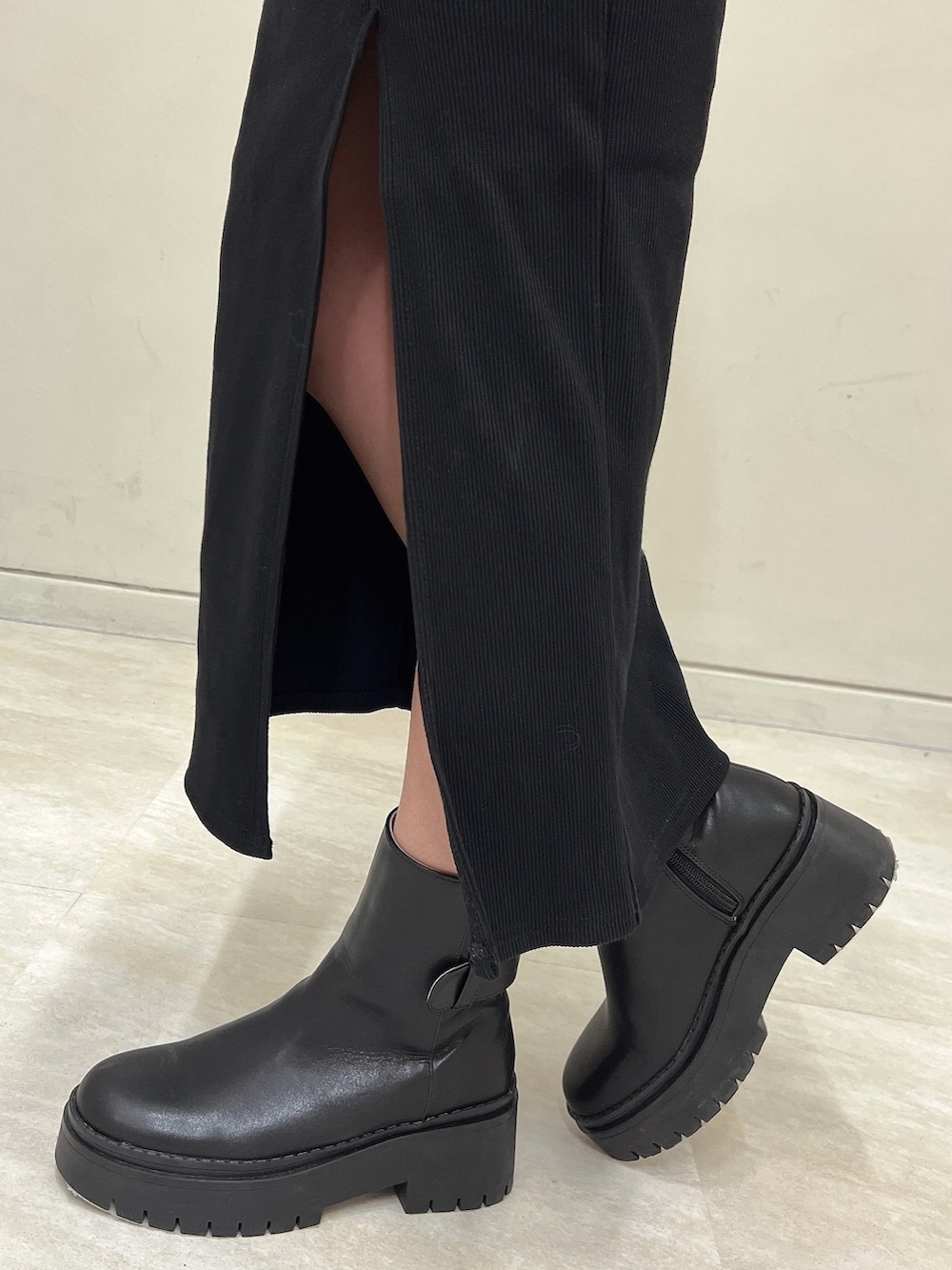 ブラック系のブーツ、ブラック系のショルダーバッグ、ブラック系のワンピースを着用したレディースの秋コーディネートの7枚目の写真