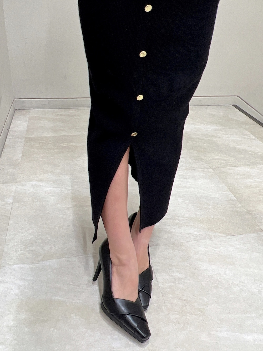 ブラック系のワンピース、ブラック系のパンプスを着用したレディースの冬コーディネートの7枚目の写真