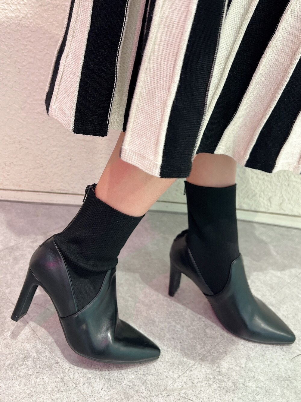 ブラック系のワンピース、ブラック系のハンドバッグ、ブラック系のブーツを着用したレディースの冬コーディネートの7枚目の写真