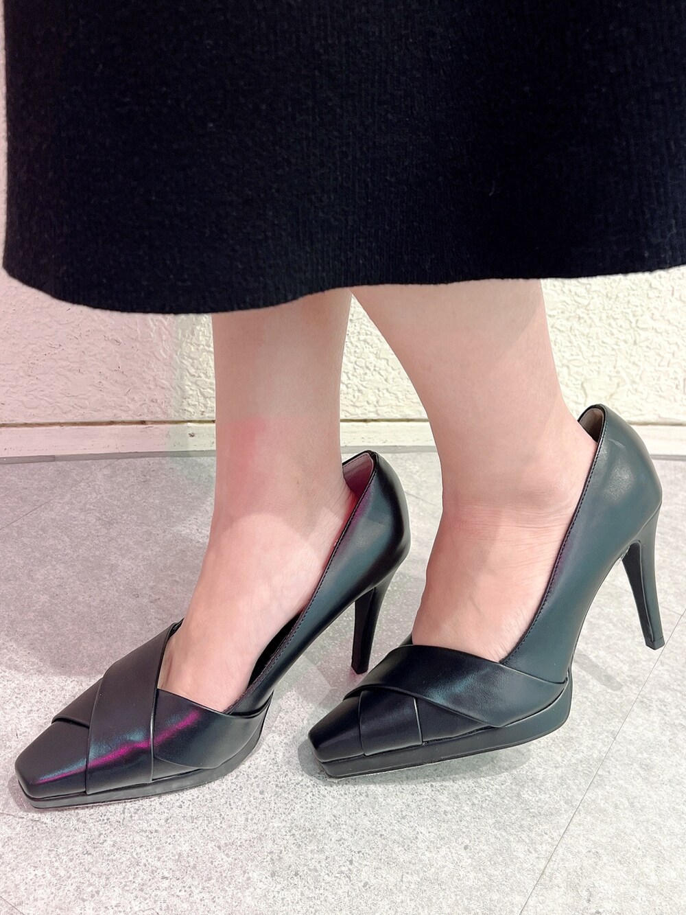 ブラック系のワンピース、ブラック系のパンプス、ブラック系のショルダーバッグを着用したレディースの冬コーディネートの6枚目の写真