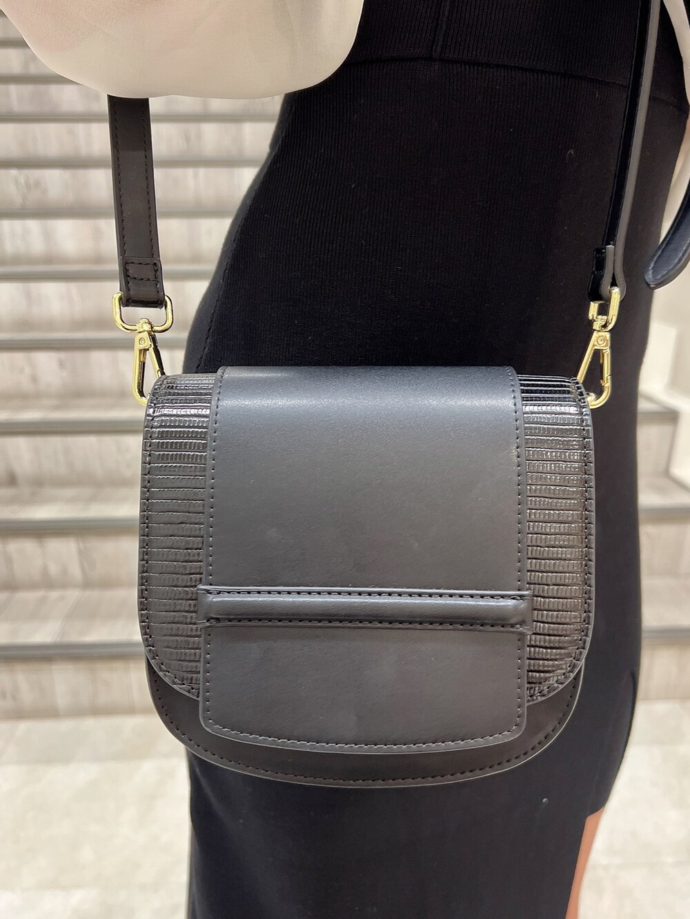 ブラック系のパンプス、ブラック系のショルダーバッグ、ブラック系のワンピースを着用したレディースの秋コーディネートの6枚目の写真