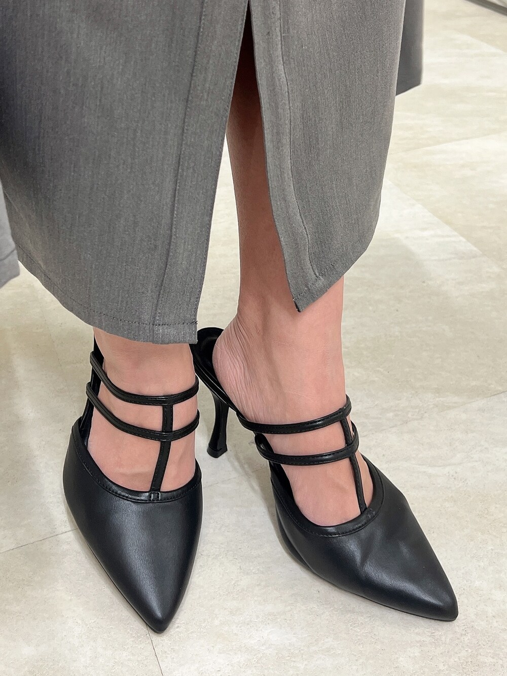 グレー系のワンピース、ブラック系のパンプス、ブラック系のハンドバッグを着用したレディースの春コーディネートの9枚目の写真