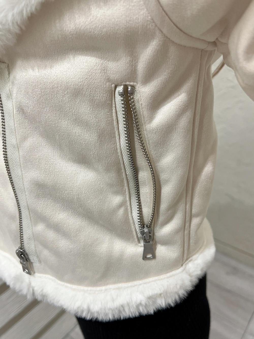 ブラック系のワンピース、ブラック系のブーツ、ホワイト系のブルゾンを着用したレディースの秋コーディネートの8枚目の写真