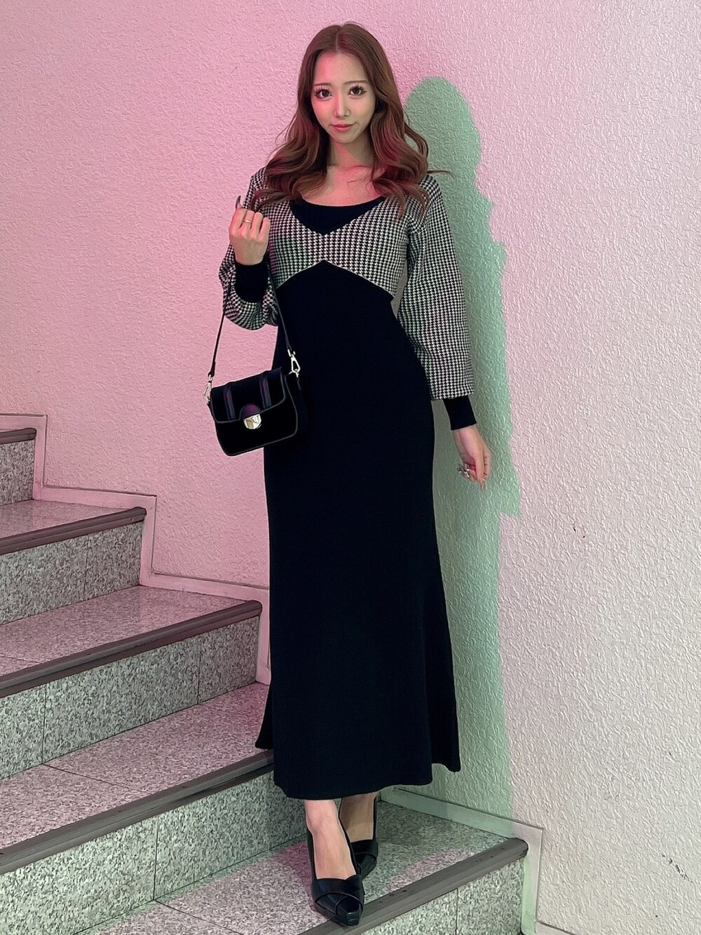 ブラック系のワンピース、ブラック系のパンプス、ブラック系のショルダーバッグを着用したレディースの冬コーディネートの2枚目の写真