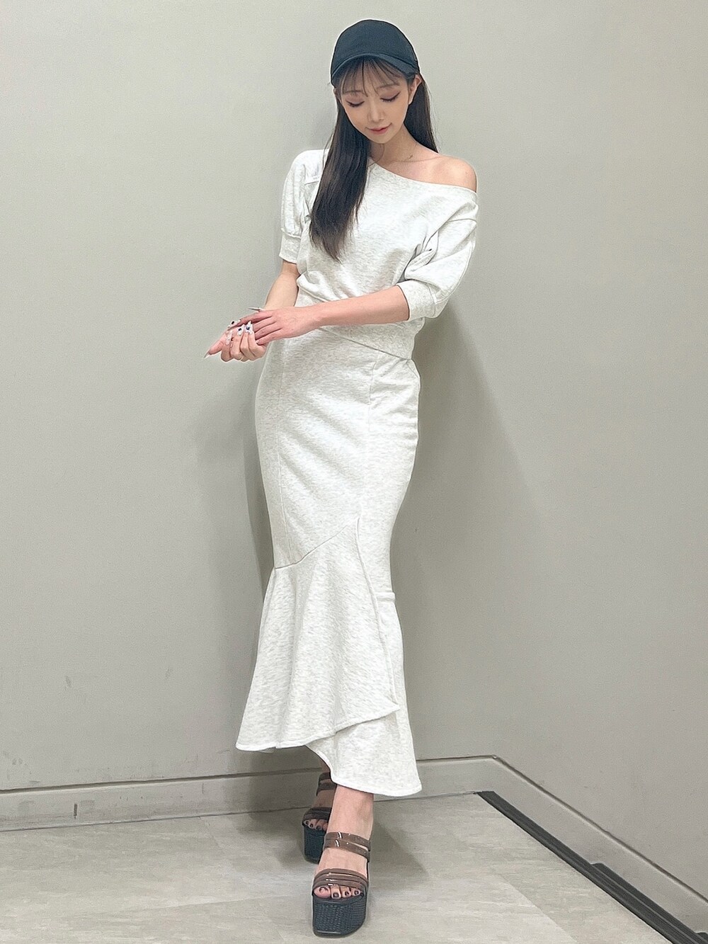 グレー系のTシャツ/カットソー、グレー系のスカート、ブラック系のサンダルを着用したレディースの春コーディネートの2枚目の写真