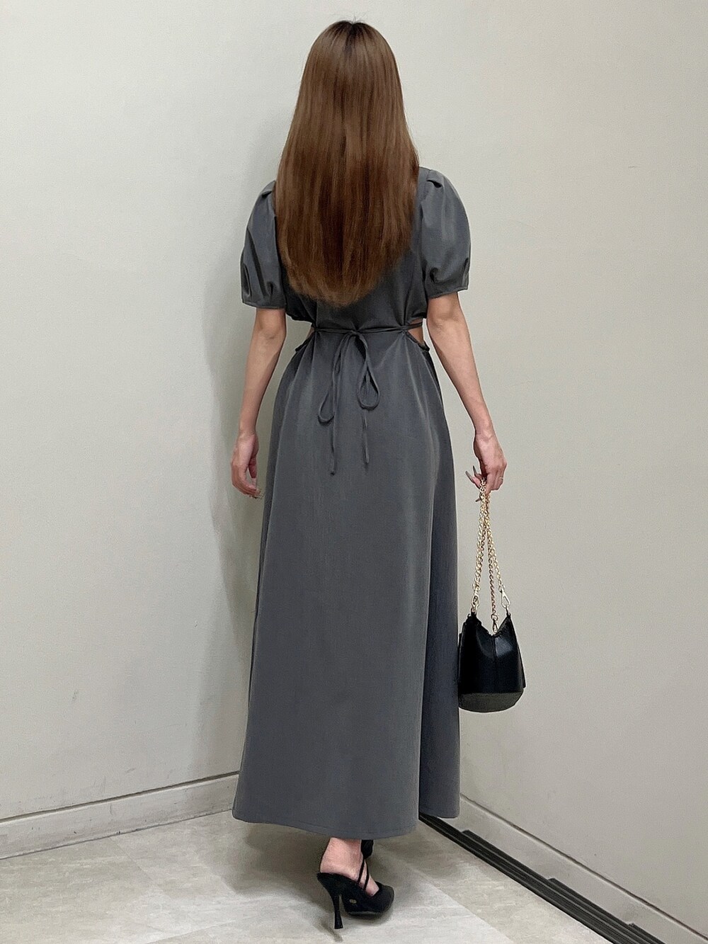 グレー系のワンピース、ブラック系のパンプス、ブラック系のハンドバッグを着用したレディースの春コーディネートの5枚目の写真