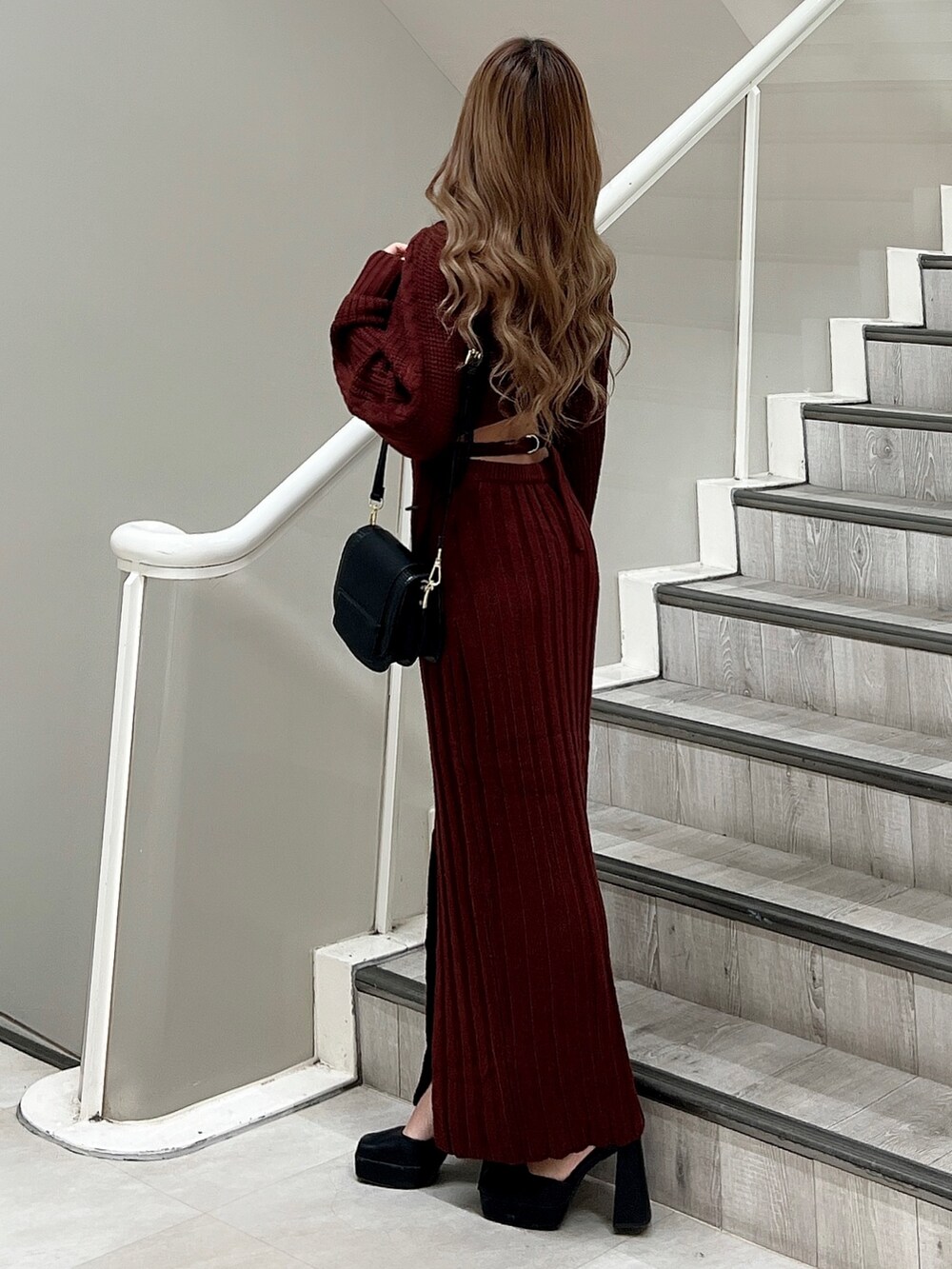 ブラック系のパンプス、ブラック系のショルダーバッグ、レッド系のワンピースを着用したレディースの秋コーディネートの2枚目の写真