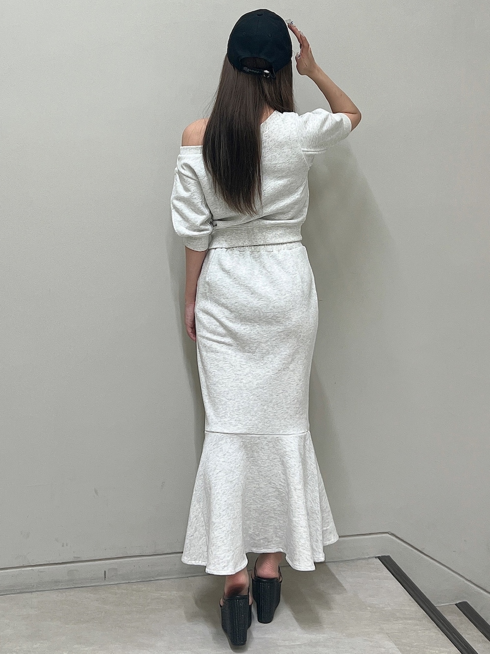 グレー系のTシャツ/カットソー、グレー系のスカート、ブラック系のサンダルを着用したレディースの春コーディネートの4枚目の写真