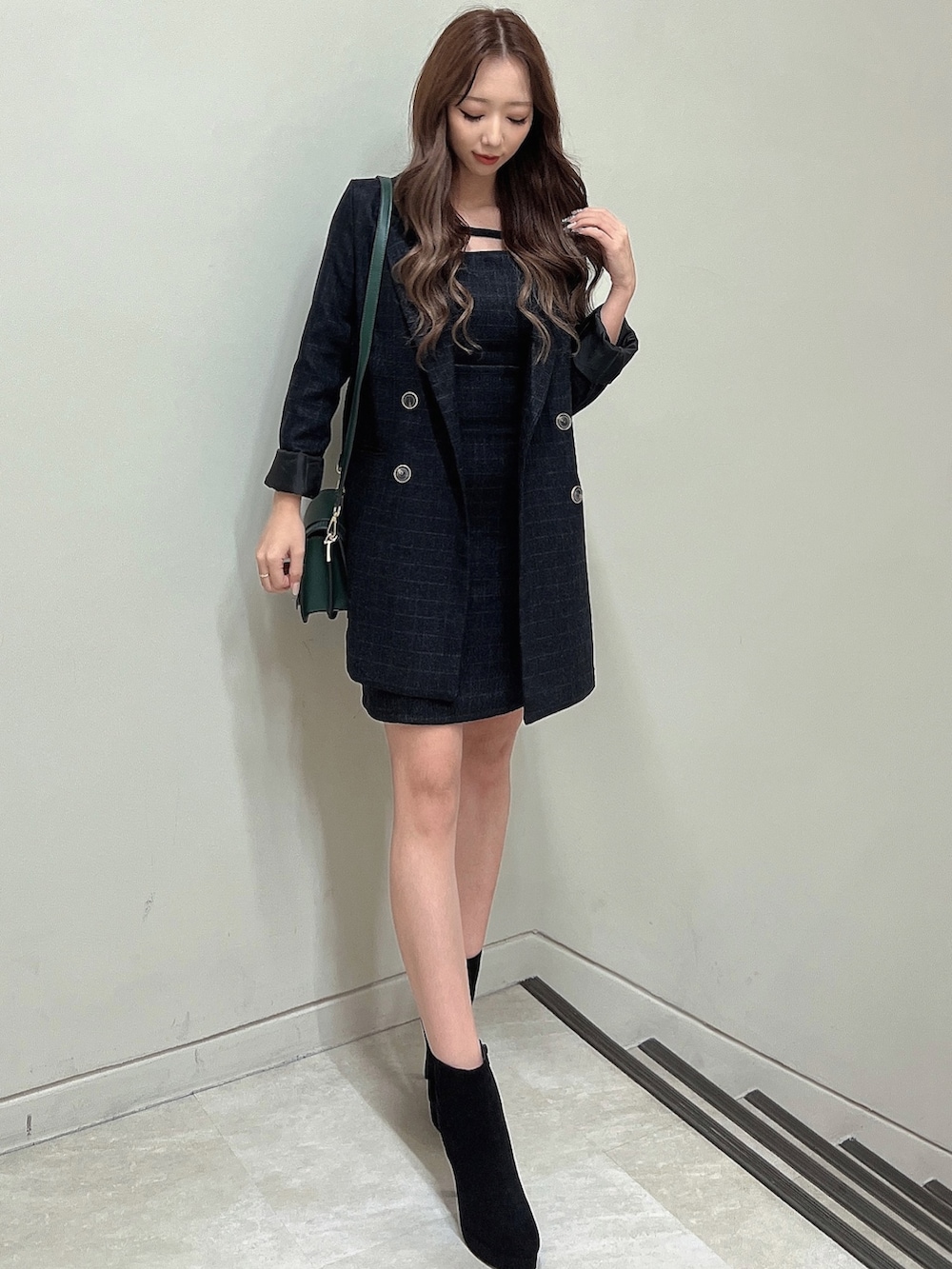 その他のテーラードジャケット、グリーン系のショルダーバッグ、ブラック系のブーツを着用したレディースの秋コーディネートの4枚目の写真