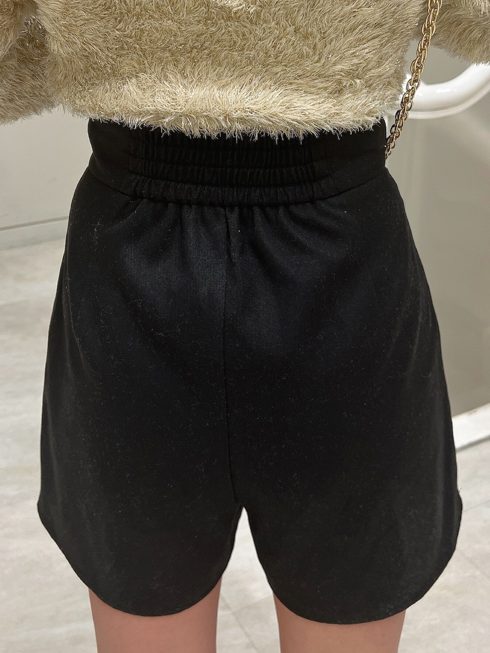 ブラック系のショルダーバッグ、ブラック系のブーツ、ベージュ系のニット/セーターを着用したレディースの冬コーディネートの7枚目の写真