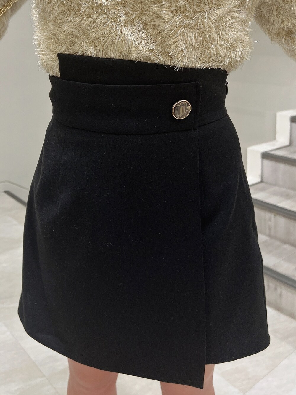 ブラック系のショルダーバッグ、ブラック系のブーツ、ベージュ系のニット/セーターを着用したレディースの冬コーディネートの6枚目の写真