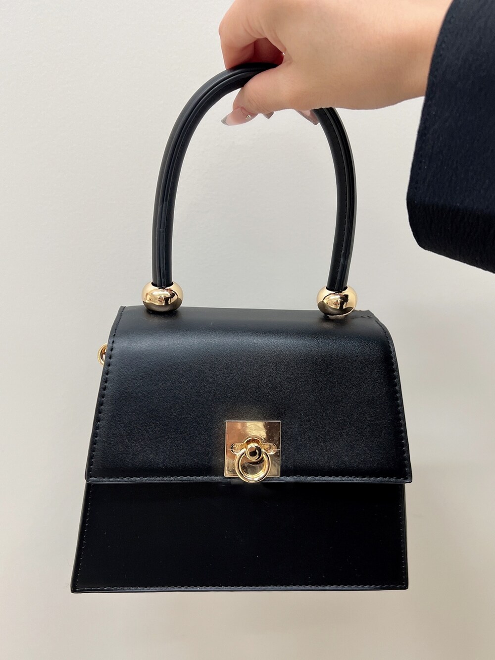 ブラック系のハンドバッグ、ブラック系のシャツ/ブラウス、ブラック系のその他パンツを着用したレディースの春コーディネートの6枚目の写真