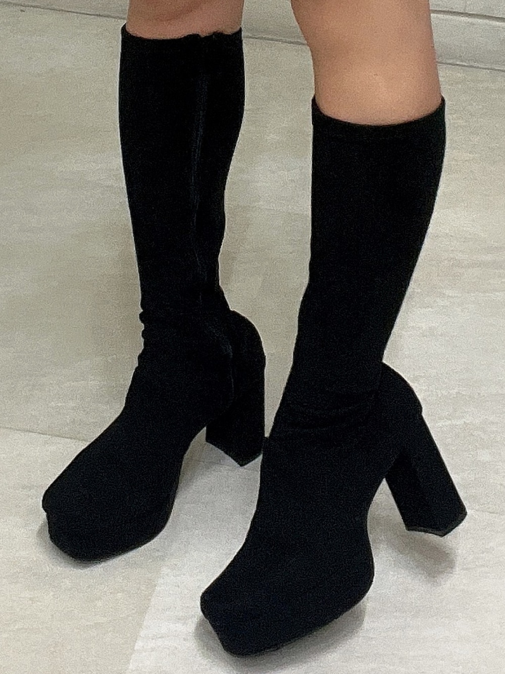 グレー系のワンピース、ブラック系のハンドバッグ、ブラック系のブーツを着用したレディースの秋コーディネートの10枚目の写真