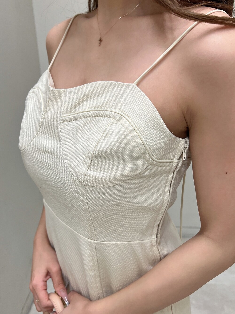 ホワイト系のパンプス、ホワイト系のワンピース、ピンク系のハンドバッグを着用したレディースの春コーディネートの4枚目の写真