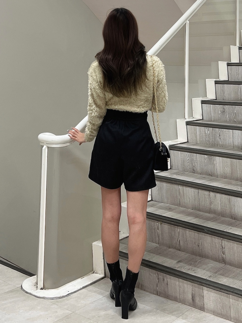 ブラック系のショルダーバッグ、ブラック系のブーツ、ベージュ系のニット/セーターを着用したレディースの冬コーディネートの3枚目の写真