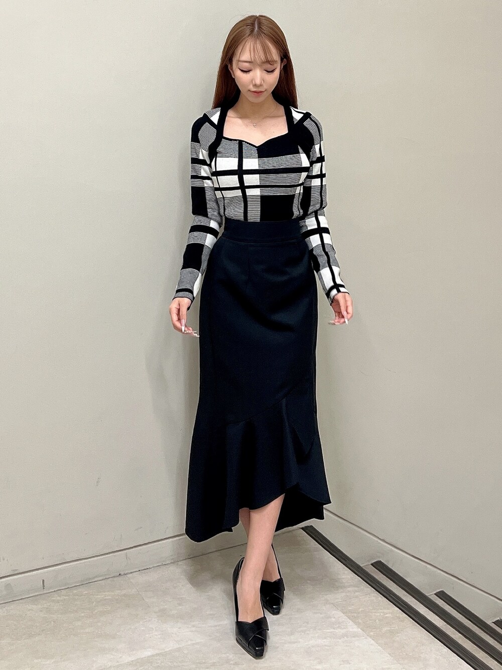 その他のニット/セーター、ブラック系のスカート、ブラック系のパンプスを着用したレディースの冬コーディネートの4枚目の写真