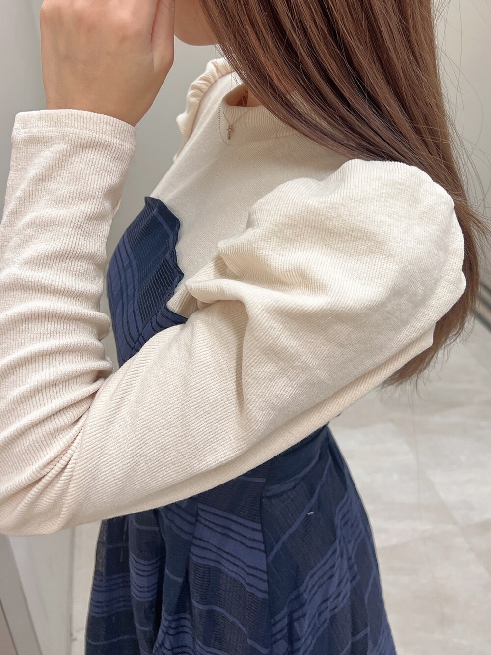 ホワイト系のパンプス、ブルー系のワンピース、ホワイト系のハンドバッグを着用したレディースの冬コーディネートの5枚目の写真