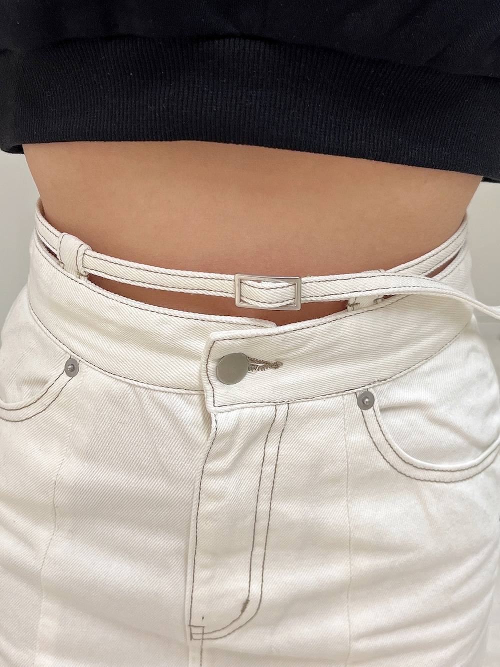 ブラック系のスウェット、ホワイト系のデニムスカート、ブラック系のパンプスを着用したレディースの冬コーディネートの6枚目の写真