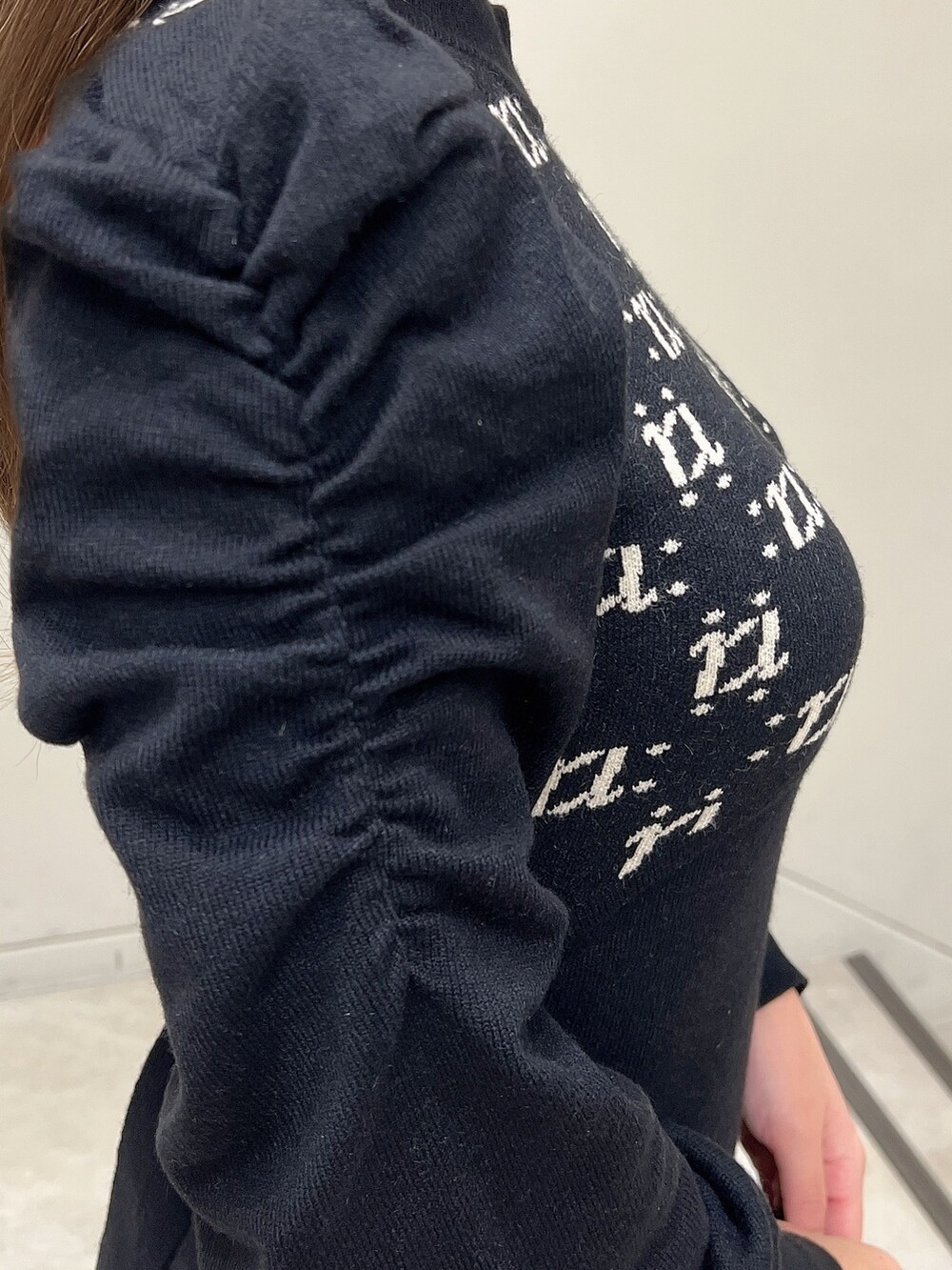 ブラック系のワンピース、ブラック系のショルダーバッグ、ブラック系のパンプスを着用したレディースの冬コーディネートの5枚目の写真