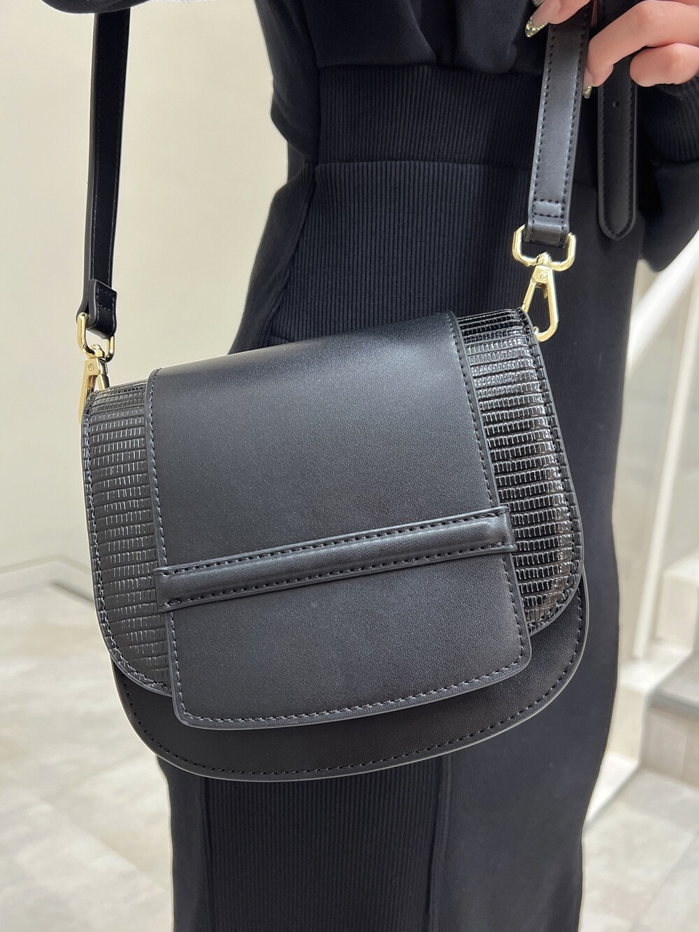 ブラック系のブーツ、ブラック系のショルダーバッグ、ブラック系のワンピースを着用したレディースの秋コーディネートの8枚目の写真