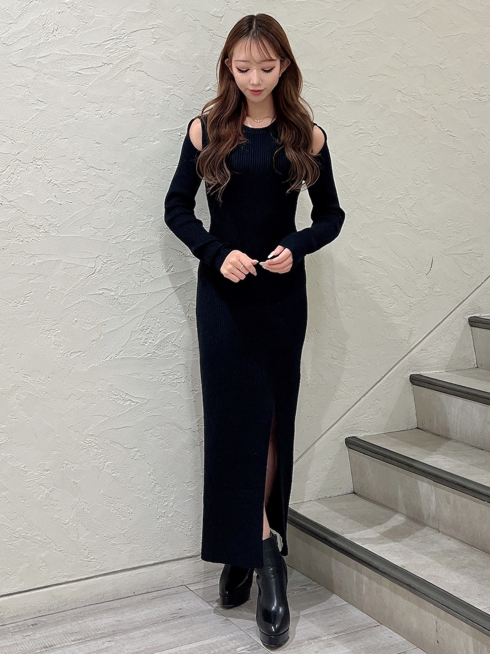 ブラック系のワンピース、ブラック系のブーツ、ホワイト系のブルゾンを着用したレディースの秋コーディネートの3枚目の写真