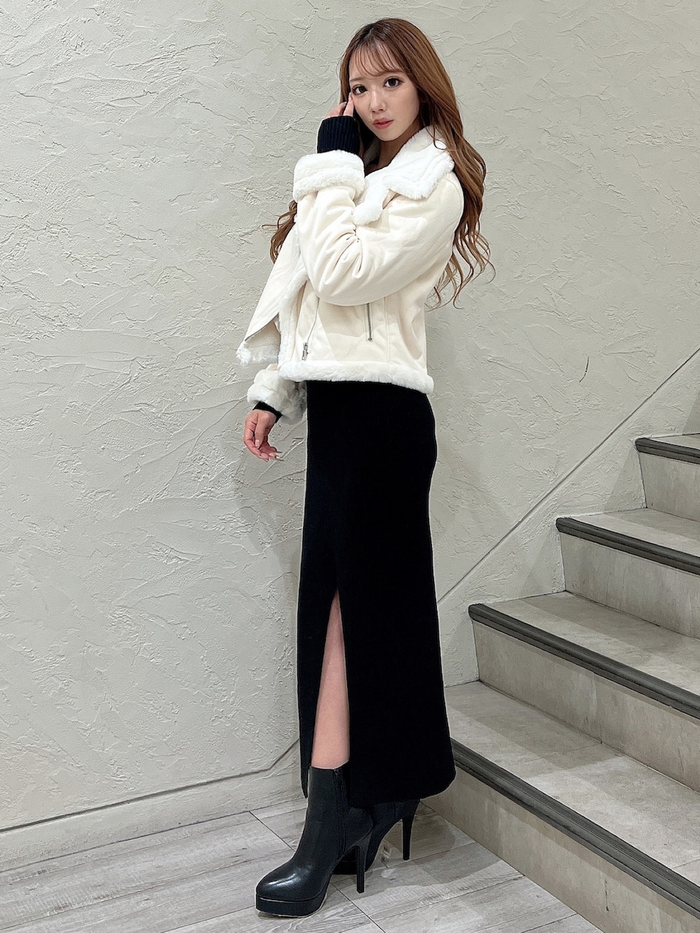 ブラック系のワンピース、ブラック系のブーツ、ホワイト系のブルゾンを着用したレディースの秋コーディネートの4枚目の写真