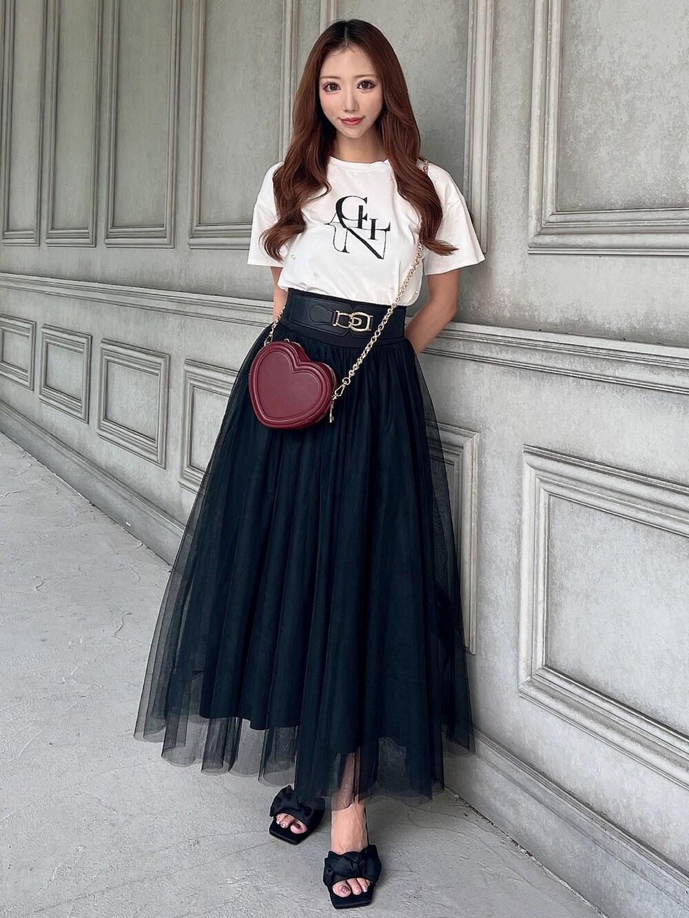 ホワイト系のTシャツ/カットソー、ブラック系のスカート、レッド系のショルダーバッグを着用したレディースの夏コーディネートの3枚目の写真