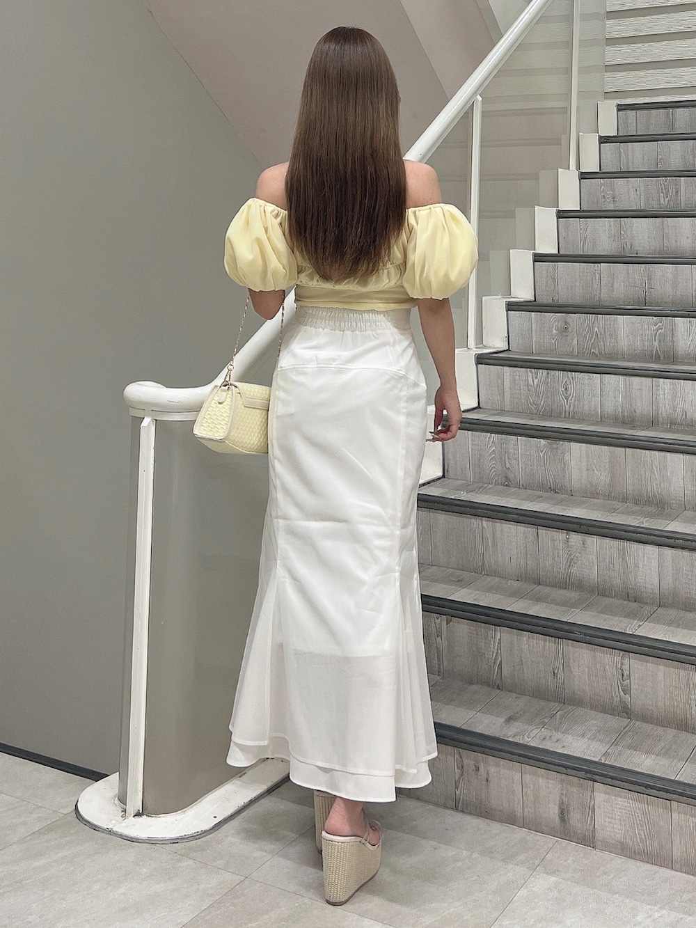 イエロー系のシャツ/ブラウス、ホワイト系のスカート、イエロー系のハンドバッグを着用したレディースの春コーディネートの4枚目の写真