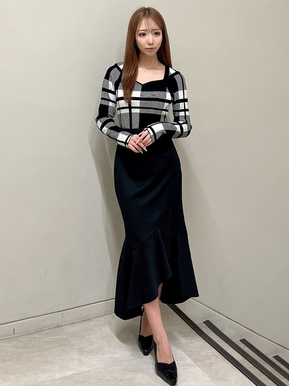 その他のニット/セーター、ブラック系のスカート、ブラック系のパンプスを着用したレディースの冬コーディネートの2枚目の写真