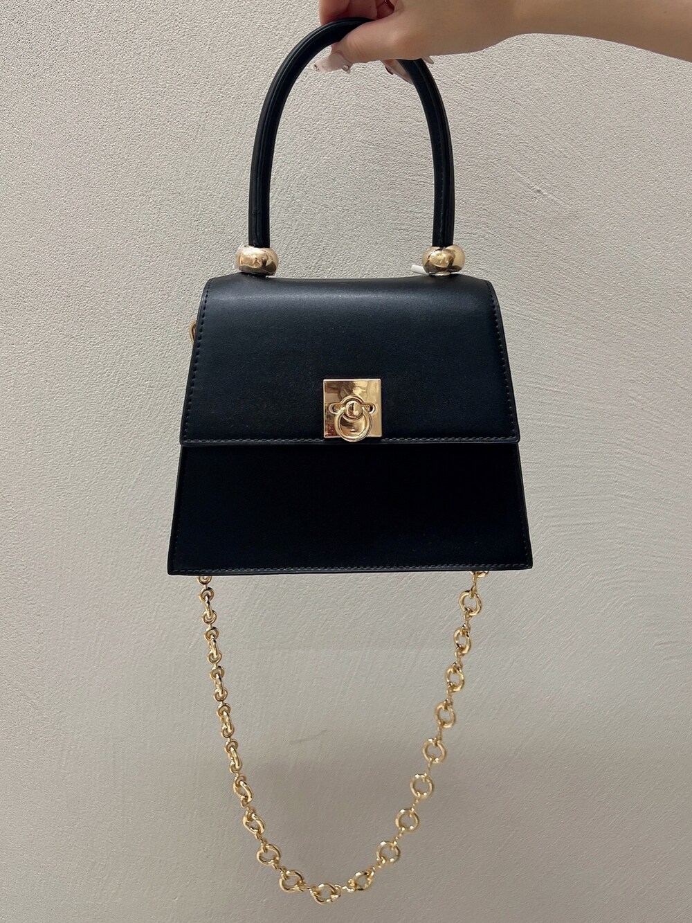 ブラック系のワンピース、ブラック系のサンダル、ブラック系のハンドバッグを着用したレディースの春コーディネートの7枚目の写真