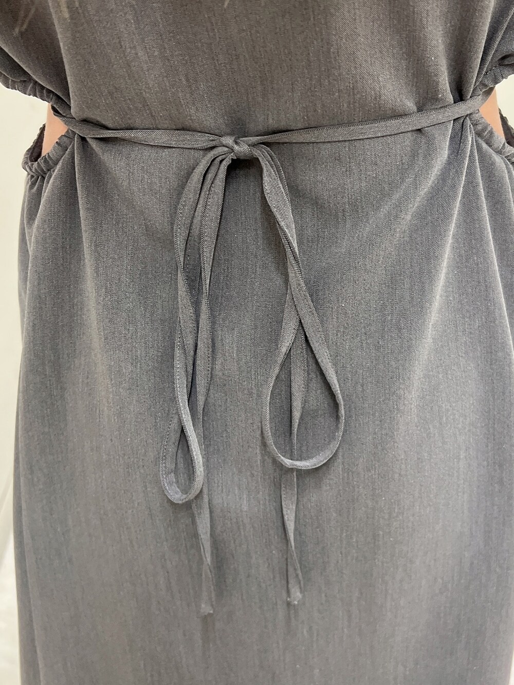 グレー系のワンピース、ブラック系のパンプス、ブラック系のハンドバッグを着用したレディースの春コーディネートの10枚目の写真