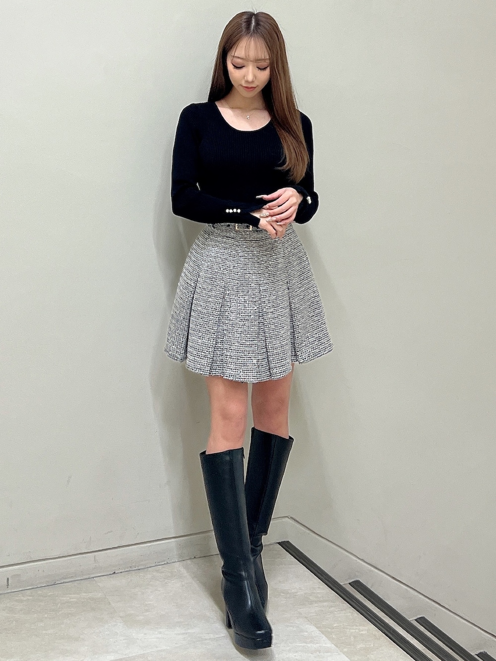 ブラック系のスカート、ブラック系のニット/セーター、ブラック系のテーラードジャケットを着用したレディースの春コーディネートの5枚目の写真